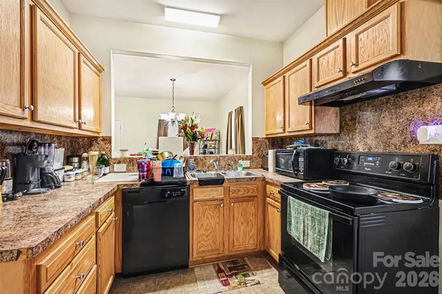 a kitchen with granite countertop a stove and a sink