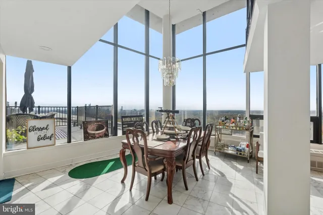 a dining room with furniture and a floor to ceiling window
