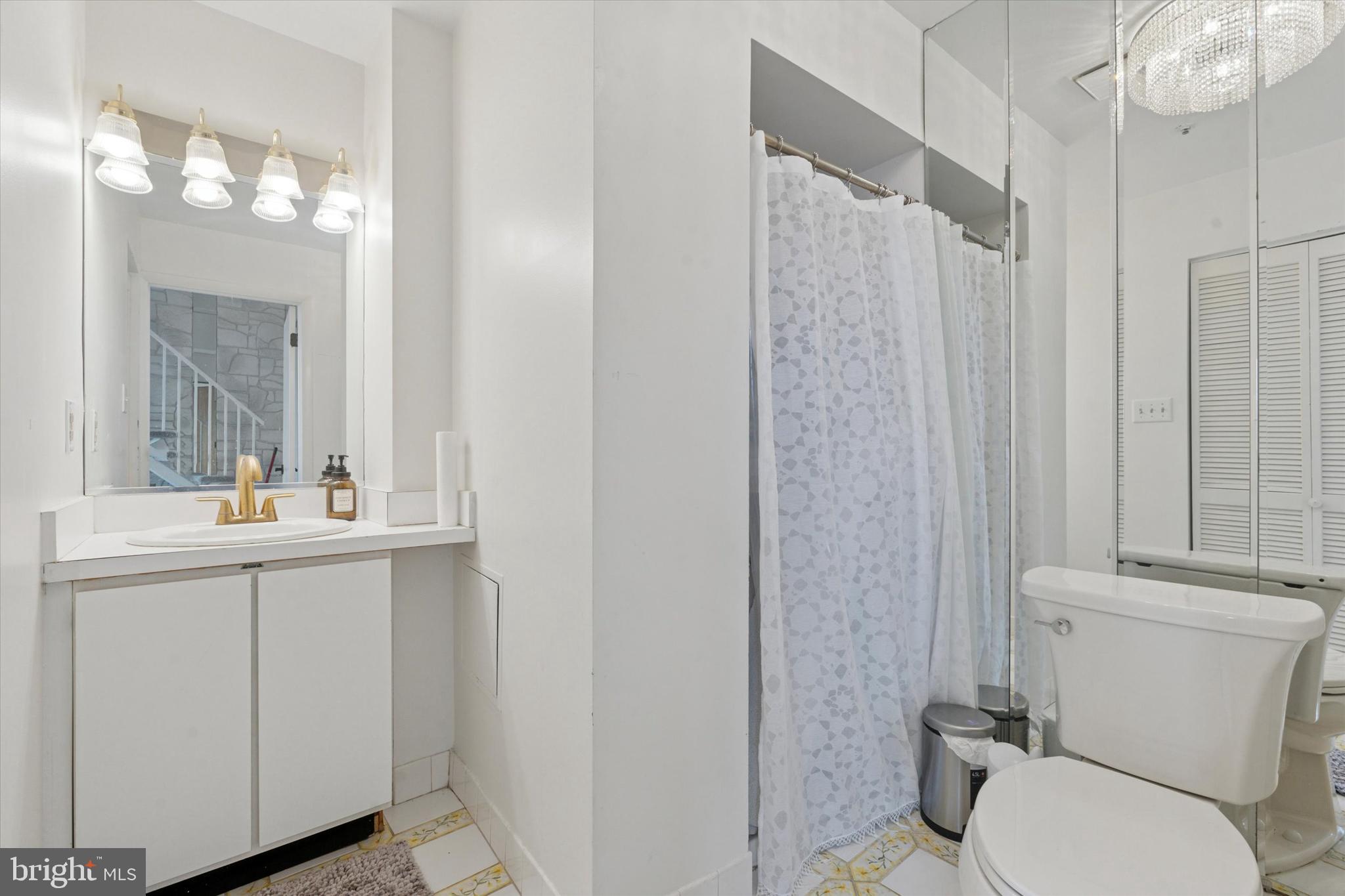 3900 West Ford Road, Unit 23B Philadelphia, PA 19131 - Photo 7 of 15 a bathroom with a toilet a sink and mirror