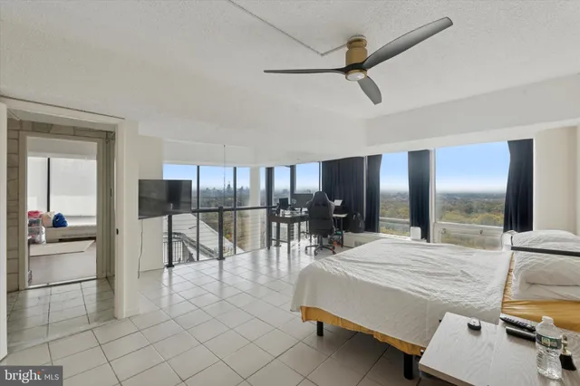 a living room with furniture a ceiling fan and a view of kitchen