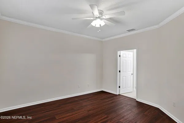 a view of an empty room with wooden floor