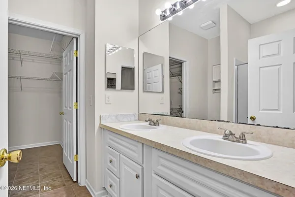 a bathroom with a double vanity sink and mirror