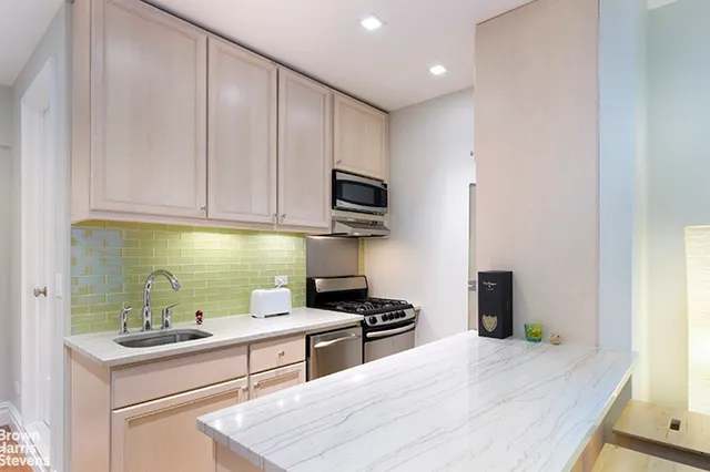 a kitchen with stainless steel appliances granite countertop a stove and a sink
