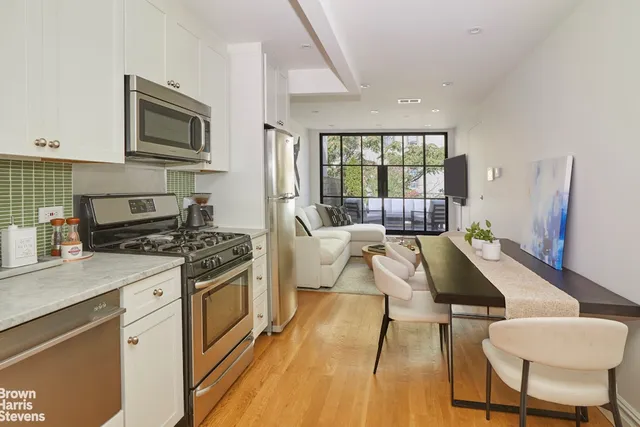 a living room with furniture a fireplace a flat screen tv and a large window