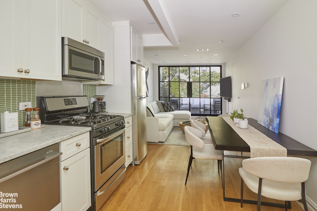 219 West 70th Street Manhattan, NY 10023 - Photo 14 of 20 a living room with furniture a fireplace a flat screen tv and a large window