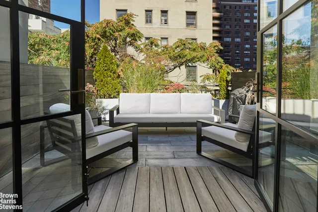 a view of a roof deck with couches and potted plants