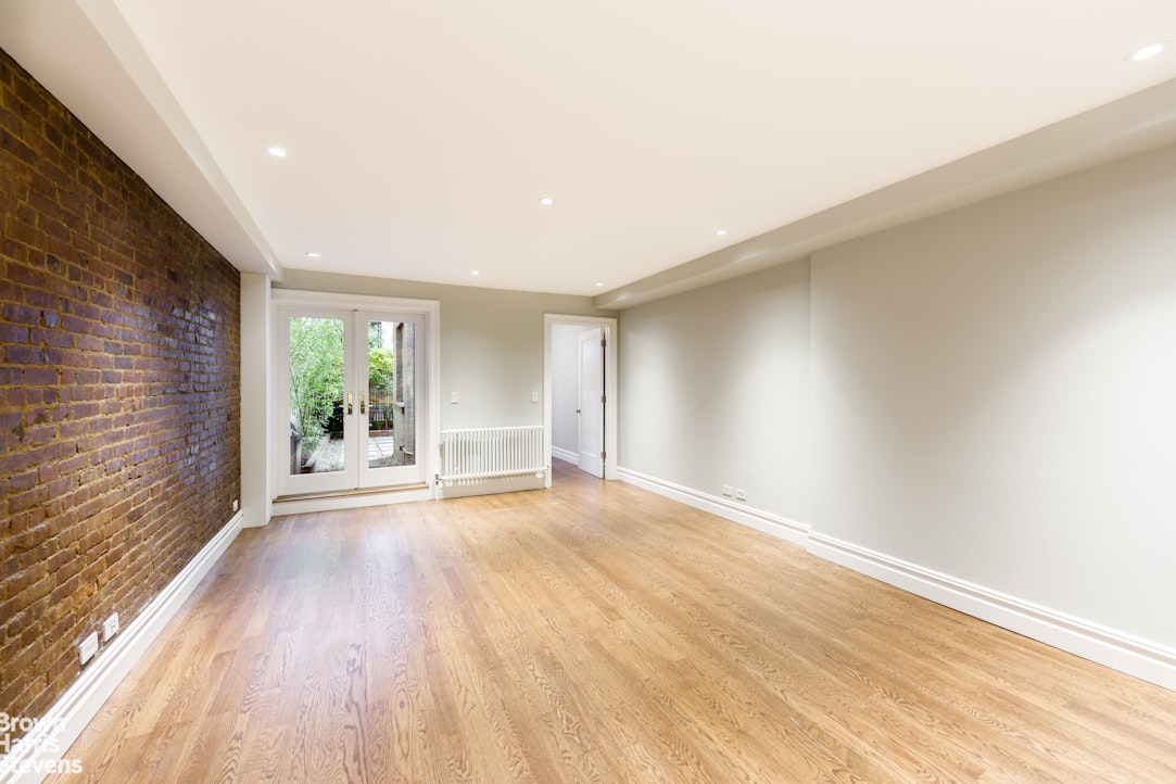 219 West 70th Street Manhattan, NY 10023 - Photo 3 of 20 a view of an empty room with wooden floor and a window