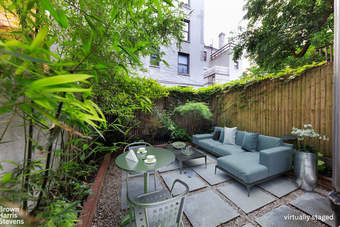 219 West 70th Street Manhattan, NY 10023 - Photo 4 of 20 a backyard of a house with table and chairs