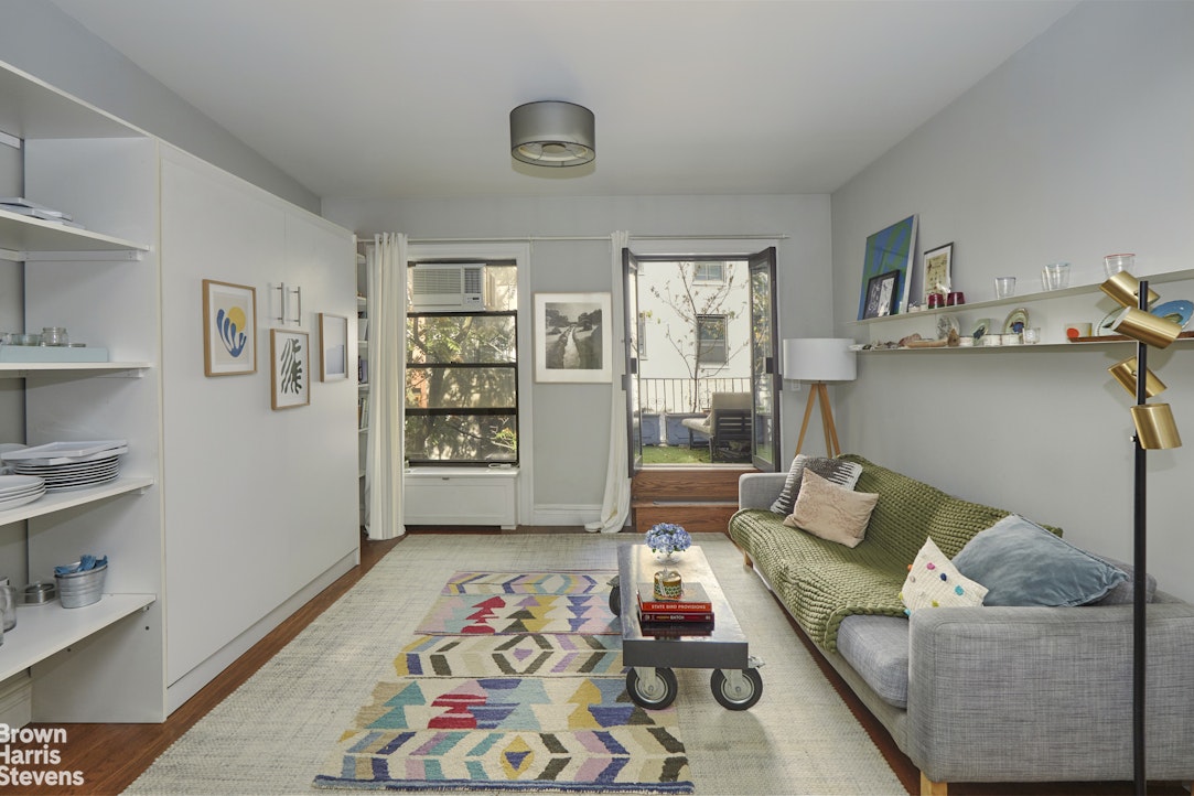 219 West 70th Street Manhattan, NY 10023 - Photo 7 of 20 a living room with furniture and painting on the wall