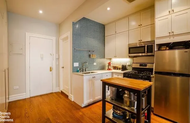 a kitchen with stainless steel appliances a stove a sink and a refrigerator