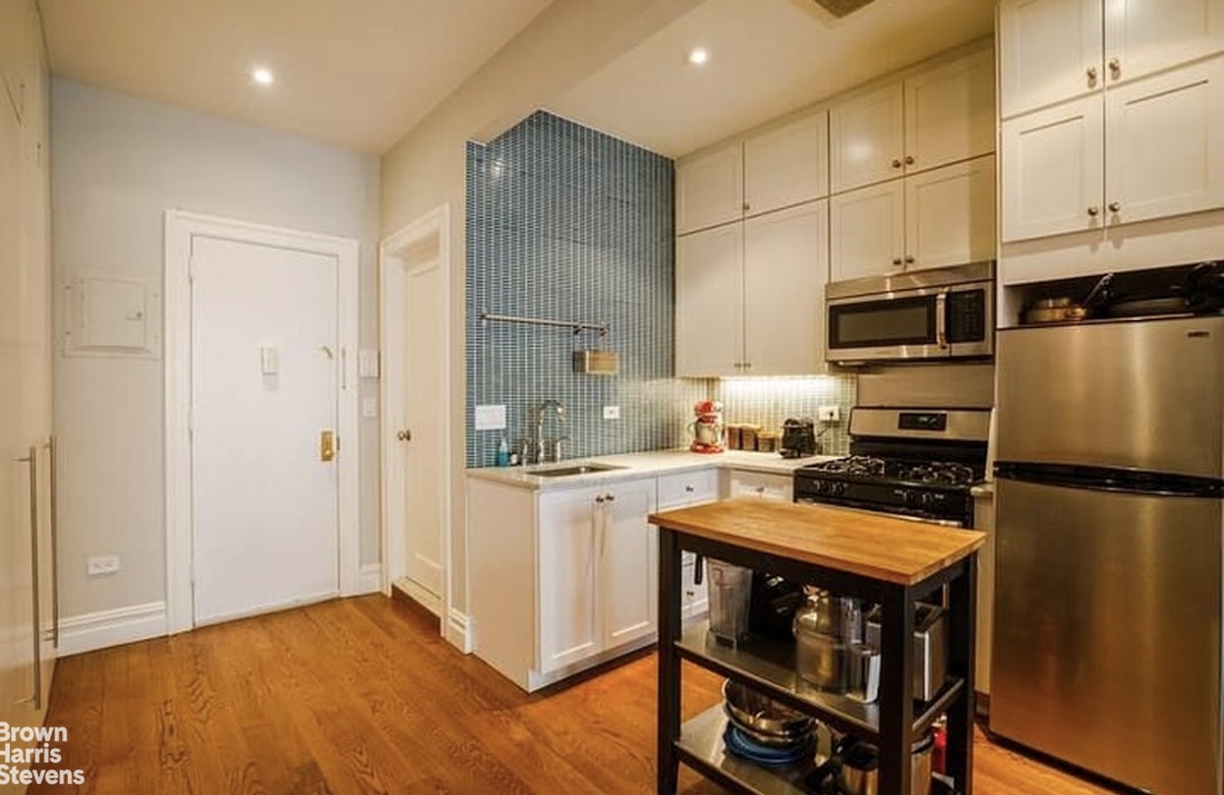 219 West 70th Street Manhattan, NY 10023 - Photo 8 of 20 a kitchen with stainless steel appliances a stove a sink and a refrigerator