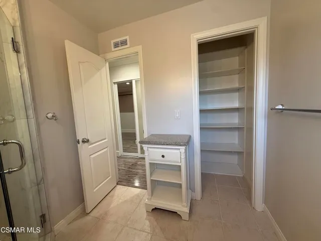 an empty room with wooden floor and a ceiling fan