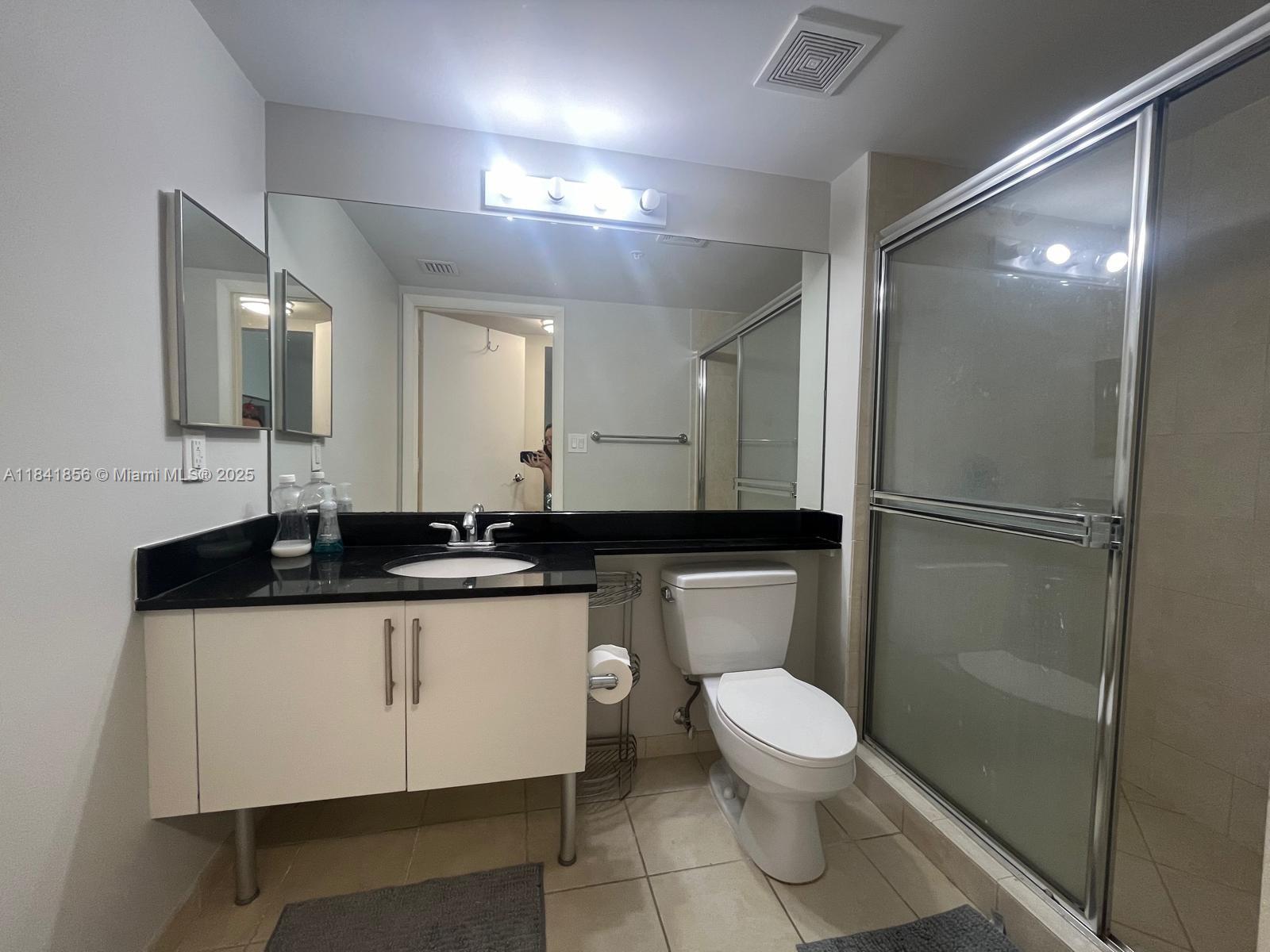 Brickell on the River Miami, FL 33131 - Photo 12 of 12 a bathroom with a granite countertop sink a toilet a mirror and shower