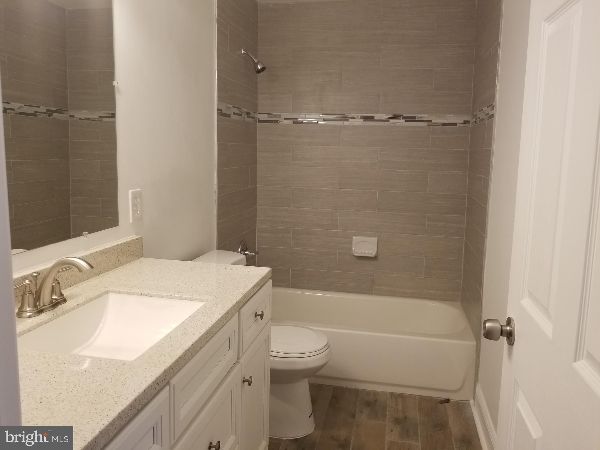 6828 Campfield Road Baltimore, MD 21207 - Photo 9 of 26 a bathroom with a granite countertop sink toilet and shower