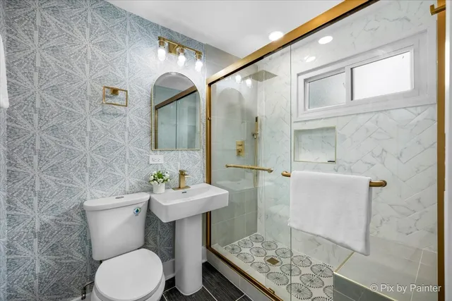a bathroom with a sink a toilet and mirror