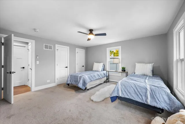 a spacious bedroom with two beds and a chandelier