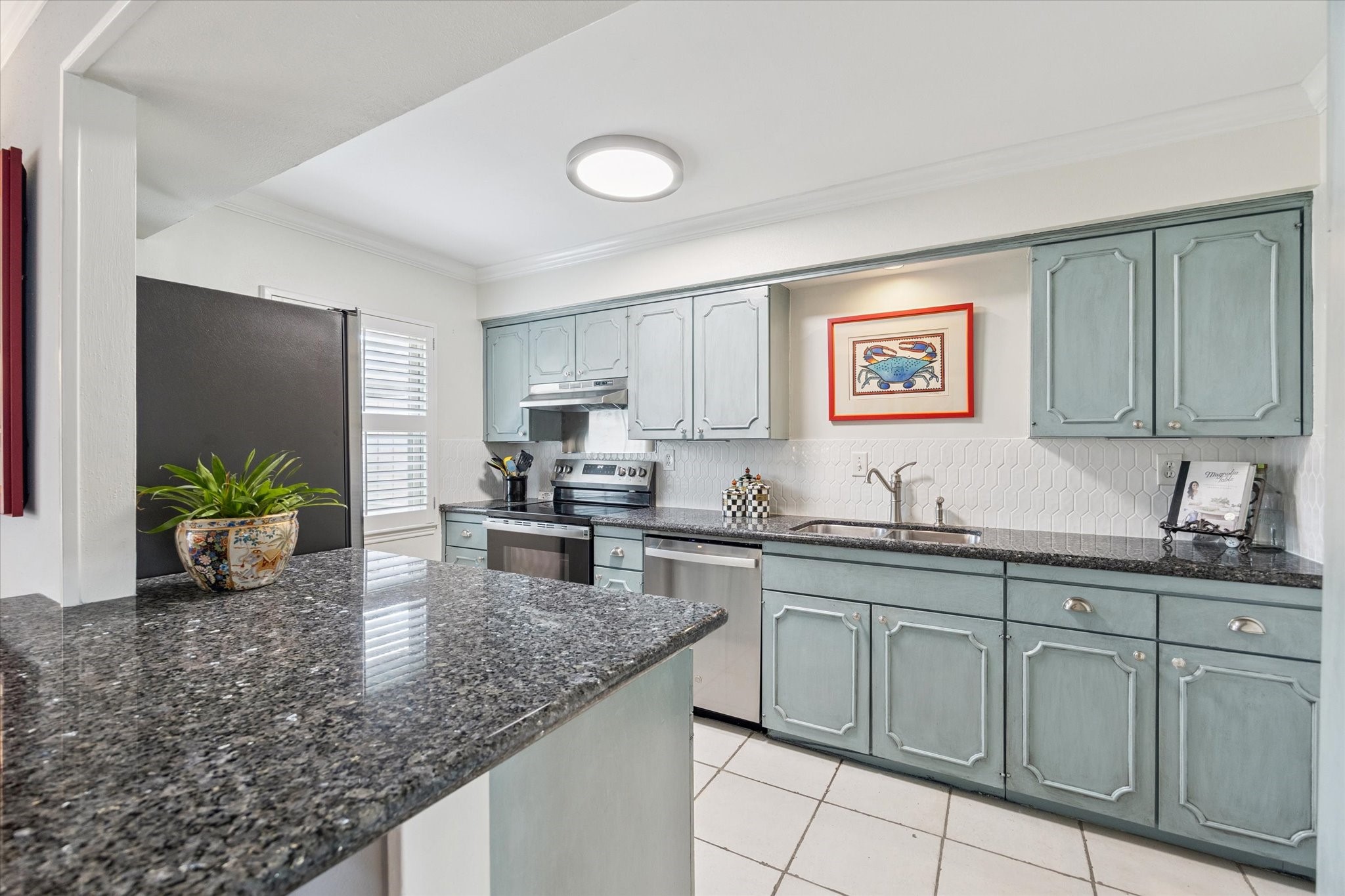 5842 Doliver Drive, Unit 47 Houston, TX 77057 - Photo 5 of 24 The kitchen is equipped with new stainless appliances, custom painted cabinetry and stylish tile backsplash.