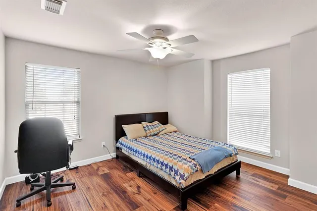 a bedroom with a bed and wooden floor