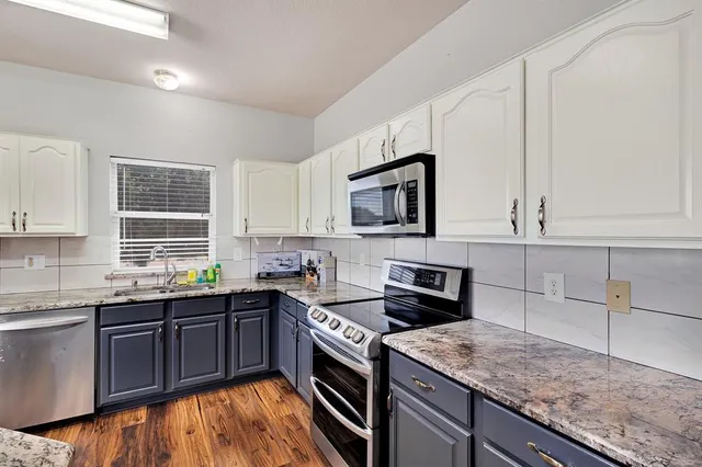 a kitchen with stainless steel appliances granite countertop a sink stove and microwave