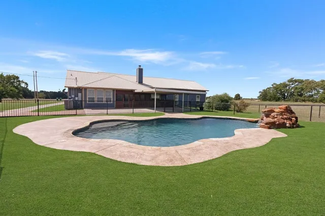 a view of a house with swimming pool and yard