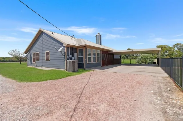 a view of a house with a yard and potted plants