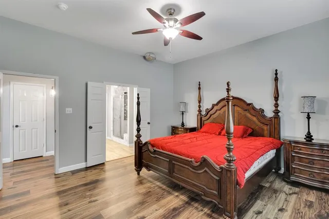 a bedroom with bed and wooden floor
