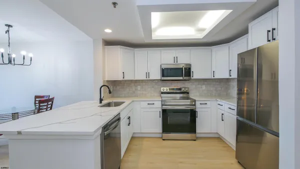 a kitchen with a sink a stove a refrigerator and cabinets
