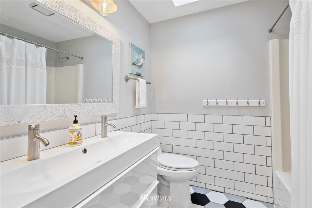 5680 Northeast Foster Road Bainbridge Island, WA 98110 - Photo 12 of 23 a bathroom with a sink a toilet and mirror