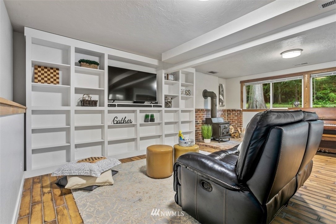 5680 Northeast Foster Road Bainbridge Island, WA 98110 - Photo 14 of 23 a living room with furniture and a flat screen tv