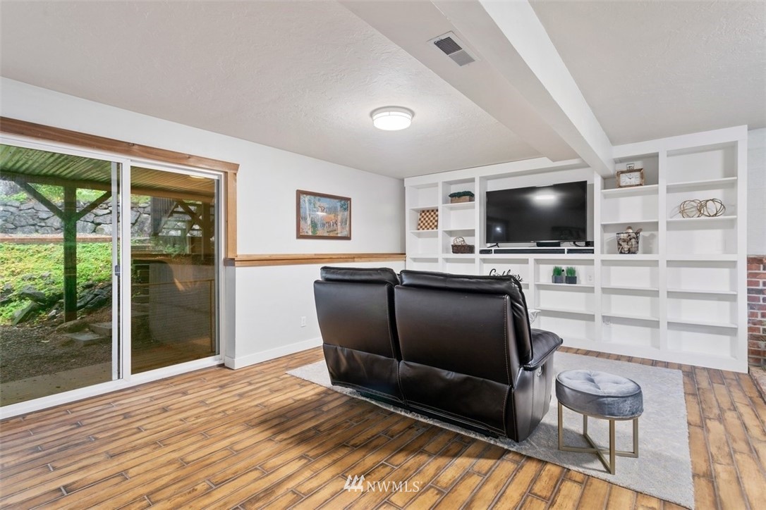 5680 Northeast Foster Road Bainbridge Island, WA 98110 - Photo 15 of 23 a living room with furniture and a flat screen tv