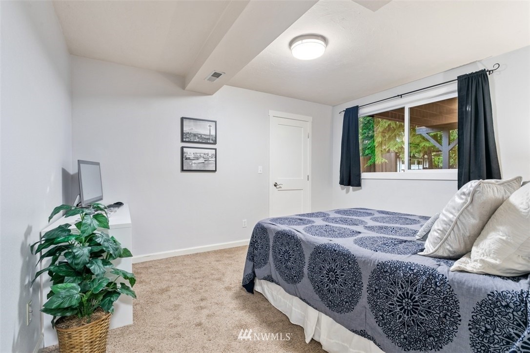 5680 Northeast Foster Road Bainbridge Island, WA 98110 - Photo 16 of 23 a bed sitting in a bedroom next to a window