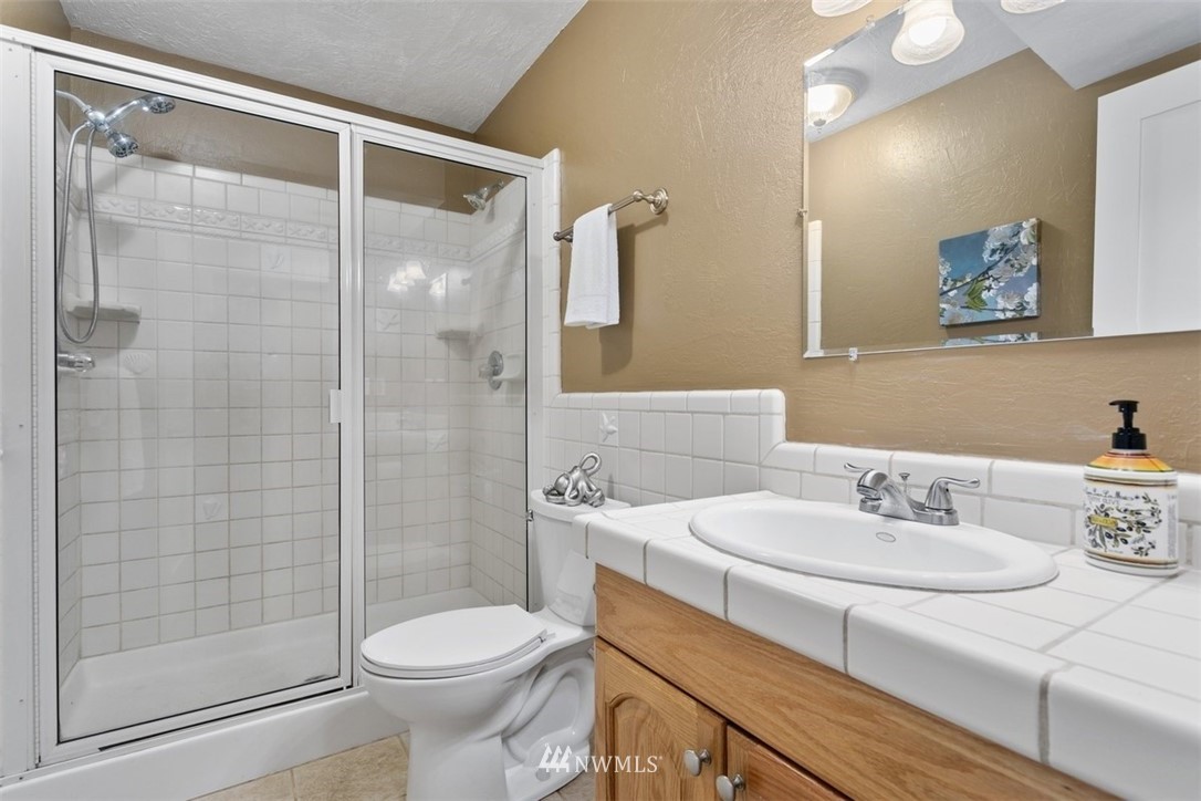 5680 Northeast Foster Road Bainbridge Island, WA 98110 - Photo 17 of 23 a bathroom with a sink toilet and shower