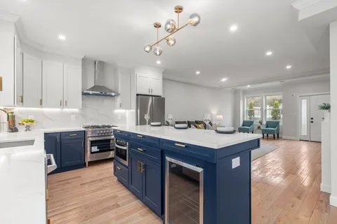 a kitchen with kitchen island granite countertop a sink stove and wooden cabinets