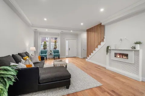 a living room with furniture and a wooden floor