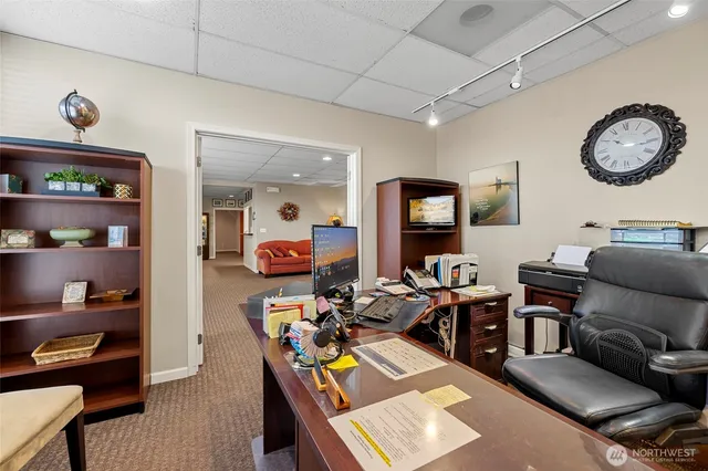 a living room with furniture a rug and a clock