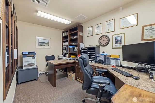 a view of a workspace with furniture and a bookshelf