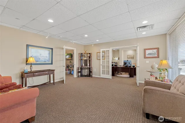 a living room with furniture and a dining table with bookshelf