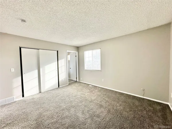an empty room with windows and closet