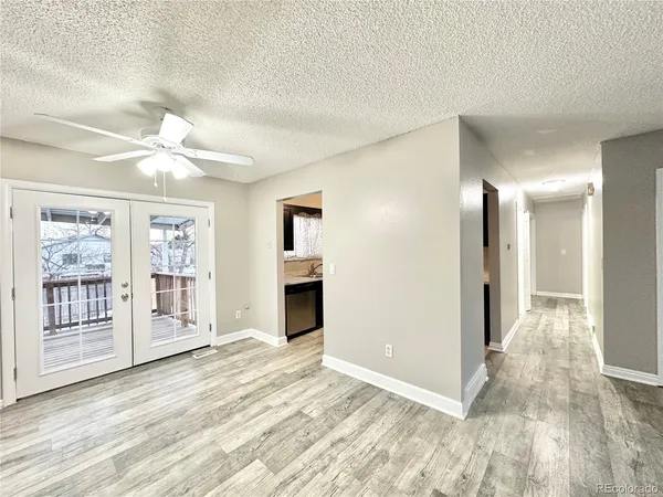 a view of an empty room with window and wooden floor