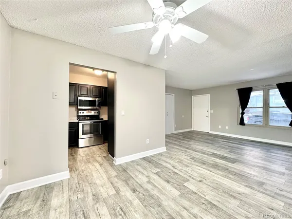 a view of a kitchen with wooden floor and a ceiling fan