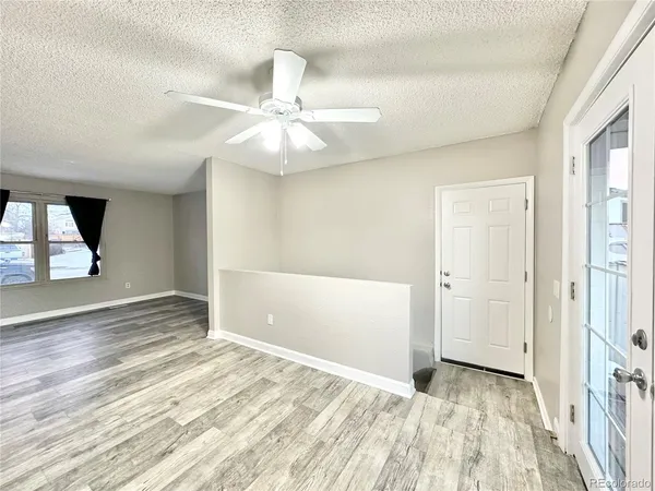 a view of a room with wooden floor and a kitchen