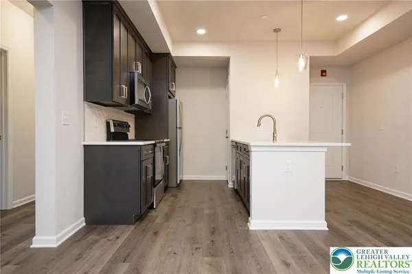 a kitchen with stainless steel appliances granite countertop a refrigerator a sink and a stove