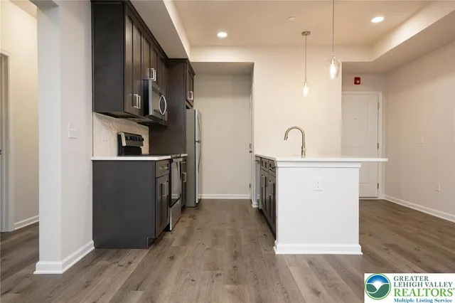 a kitchen with stainless steel appliances granite countertop a refrigerator a sink and a stove