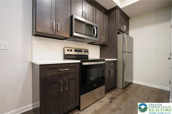 a kitchen with stainless steel appliances granite countertop a stove microwave and refrigerator