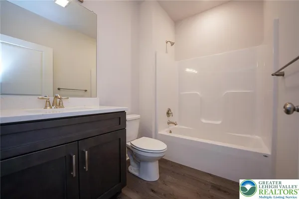 a bathroom with a sink a toilet a mirror and shower