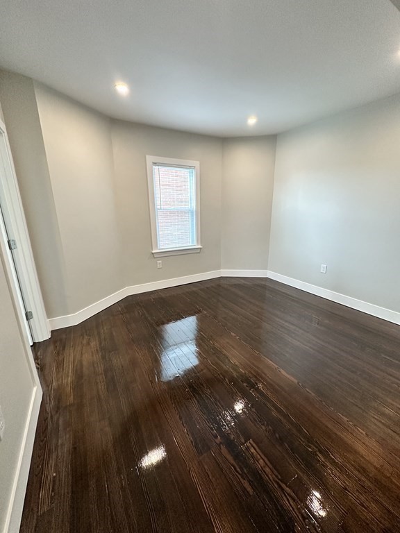 15 Tuttle Street, Unit 2 Revere, MA 02151 - Photo 11 of 17 an empty room with wooden floor and windows