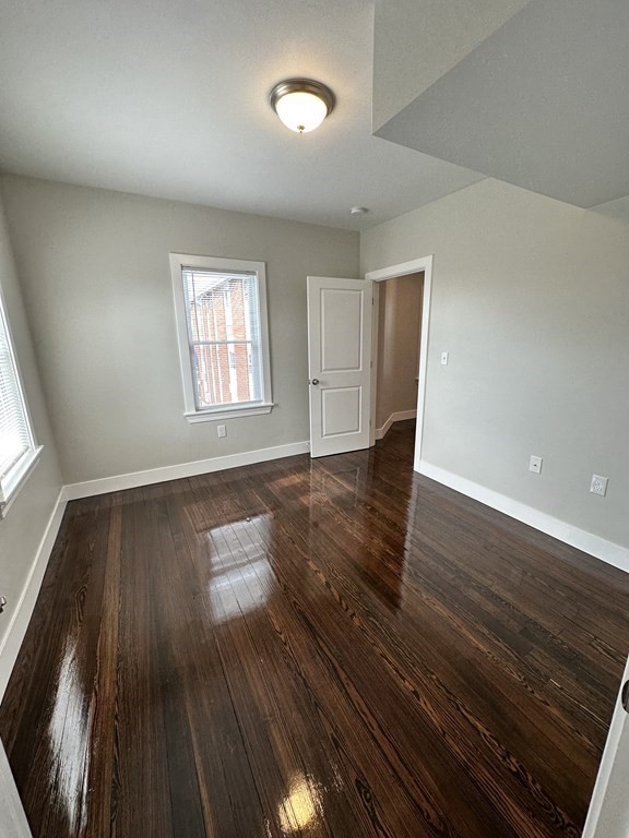 15 Tuttle Street, Unit 2 Revere, MA 02151 - Photo 15 of 17 an empty room with wooden floor and windows