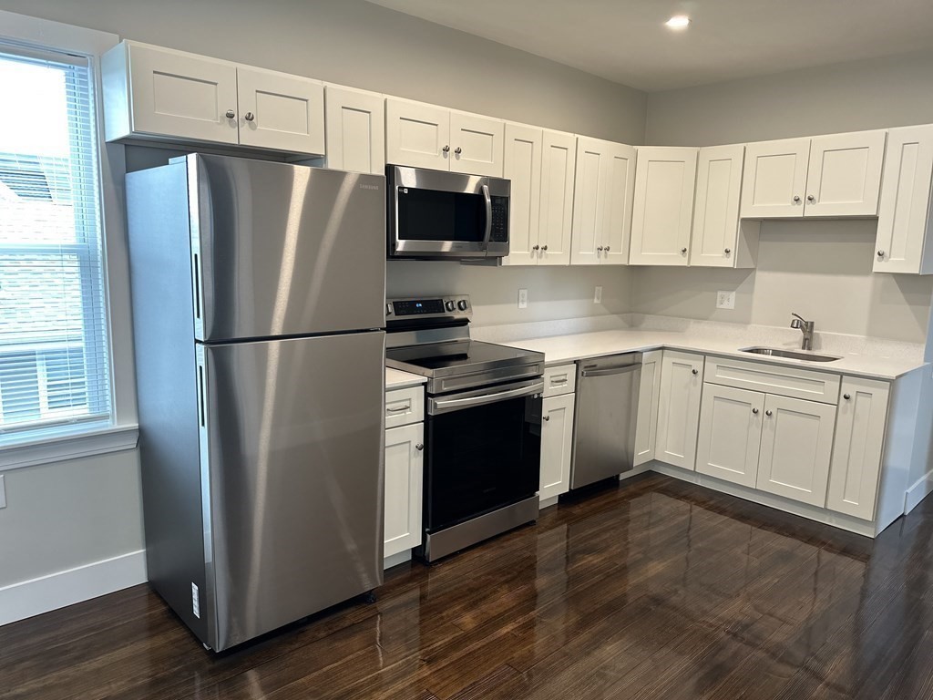 15 Tuttle Street, Unit 2 Revere, MA 02151 - Photo 3 of 17 a kitchen with cabinets stainless steel appliances and a window