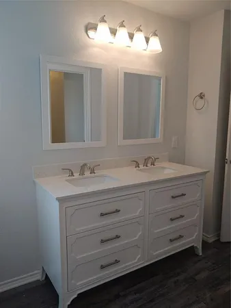 a bathroom with a double vanity sink and mirror