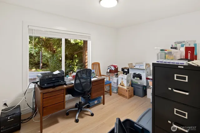a view of a workspace with furniture and a window